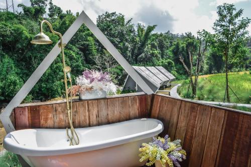a bath tub sitting in front of a wooden wall at AomlongHomenon(อมลอง โฮมนอน) in Ban Bong