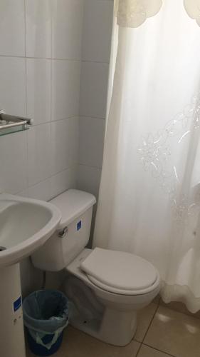 Baño blanco con aseo y lavamanos en Mini departamento cerca de playa, en Iquique