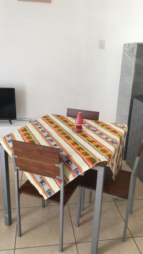 una mesa con una taza roja encima en Mini departamento cerca de playa, en Iquique