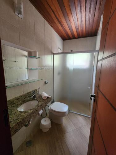 a bathroom with a toilet and a sink and a shower at Pousada Sítio do Sossego in Monte Alegre do Sul