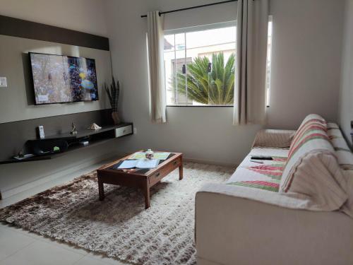 sala de estar con sofá y mesa de centro en Casa temporada AURORA en São João Batista do Glória