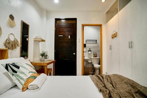 a bedroom with a bed and a bathroom with a toilet at Pallet Homes - Gran Plains in Iloilo City