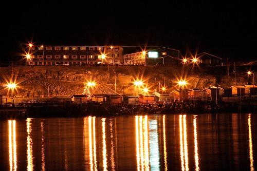 a dock with lights on the water at night at St Christopher's Hotel in Channel-Port aux Basques