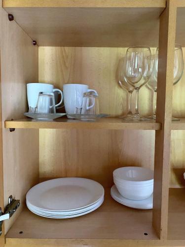 a shelf with plates and wine glasses on it at Lisbon Airport Guesthouse in Lisbon