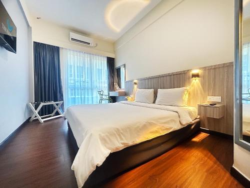 a hotel room with a large bed and a window at The Elopura Hotel in Sandakan