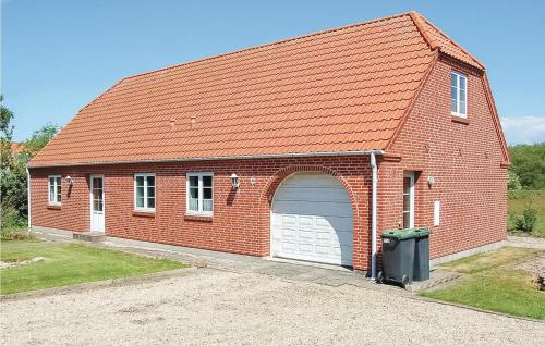 a red brick building with a white garage at Holiday Home Vadgårdsvej in Nørre Nebel