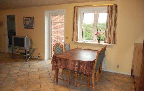 a dining room with a table and chairs and a television at Holiday Home Vadgårdsvej in Nørre Nebel