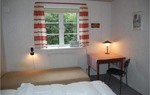 a bedroom with a bed and a desk and a window at Holiday Home Vadgårdsvej in Nørre Nebel