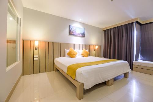 a bedroom with a large bed and a window at Andakira Hotel - SHA Extra Plus in Patong Beach