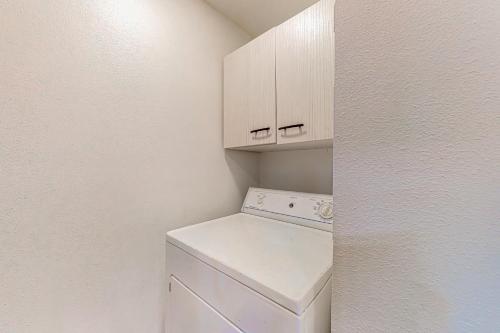 a white laundry room with a washer and dryer at The Hideaway in Langley