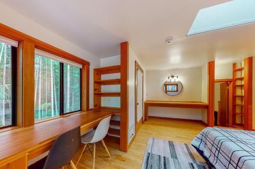 a bedroom with a bed and a desk and windows at The Hideaway in Langley