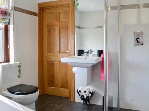 a bathroom with a sink and a toilet and a shower at Maryland Cottage in Aberargie