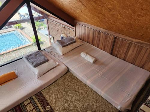een slaapkamer met 2 bedden en een zwembad bij Homestay Umbai Kelana in Merlimau