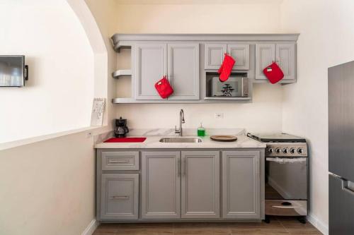 a kitchen with white cabinets and a sink and a stove at Healing in the City in Montego Bay