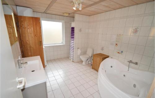 uma casa de banho branca com uma banheira e um WC em Amazing Home In Fars With Kitchen em Hvalpsund