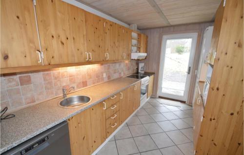 a kitchen with wooden cabinets and a sink at Holiday Home Illeris Farsø Ix in Hvalpsund
