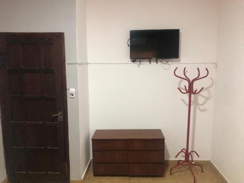 Zimmer mit einem TV an der Wand neben einer Tür in der Unterkunft Alojamiento Temporario “LG” in Presidencia Roque Sáenz Peña