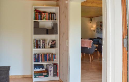 a book shelf filled with books in a living room at Three-Bedroom Holiday Home In Jagerspris in Jægerspris