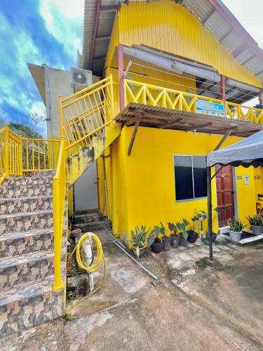a yellow house with a yellow staircase in front of it at Perhentian Sri Tanjung , Kampung Nelayan Pulau Perhentian in Perhentian Island