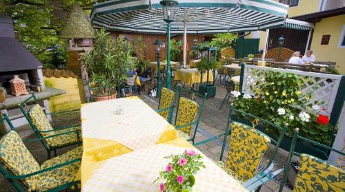 a patio with a table and chairs with flowers on it at Gasthof Engelhof in Gmunden