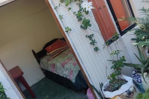 a room with a bed and a wall with plants at La Casa del Pan de Yuca Baños in Baños