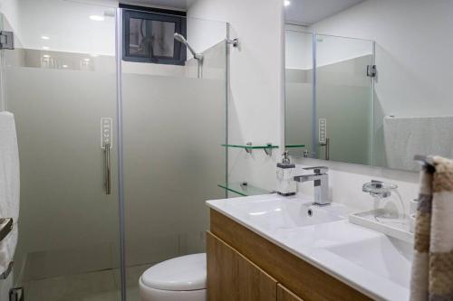 a bathroom with a toilet and a sink and a shower at Livera in Santiago de los Caballeros