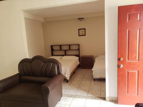 a bedroom with a bed and a couch and a chair at Sunrise Hotel in Corn Island