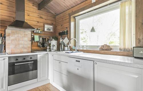 a kitchen with white cabinets and a window at Stunning Home In Västra Torup With Wifi in Västra Torup