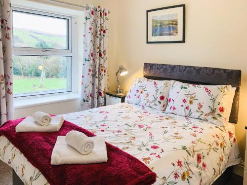 a bedroom with a bed with towels on it at Isallt in Nantlle