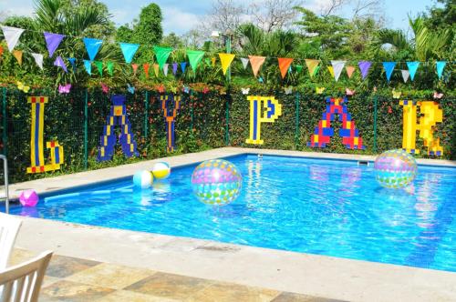 a swimming pool with balls in the water and flags at Paris FC Express in Poza Rica de Hidalgo