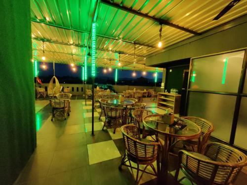 a restaurant with tables and chairs and green lights at Hotel Townhouse at Udaipur City Railway Station in Udaipur