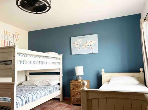 a bedroom with two bunk beds and a blue wall at LUX 3 MASTER BDROOM ON SANDY BEACH w NO CLEAINING FEE in Puerto Peñasco