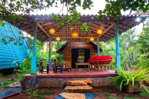 uma pérgola de madeira com uma mesa e cadeiras num pátio em villa ovita em Talpe