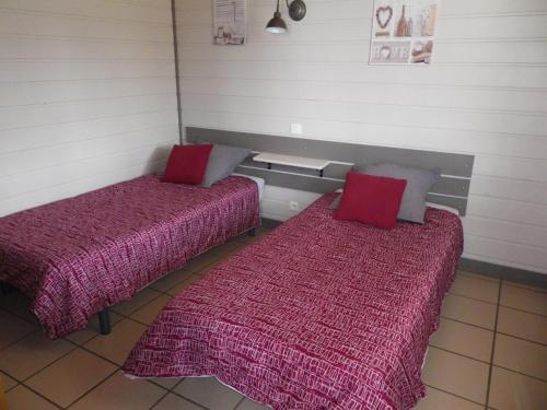 2 camas con almohadas rojas en una habitación en Gîte Bouquehault, 3 pièces, 4 personnes - FR-1-376-65, en Bouquehault