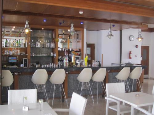 a restaurant with white chairs and a bar at Senator Hotel Apartments - Adults Only in Ayia Napa