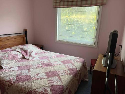 a bedroom with a bed and a window at Acogedora casa en Pingueral in Concepción