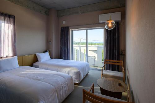 um quarto de hotel com duas camas e uma janela em MEGURU l 巡 em Ishigaki Island