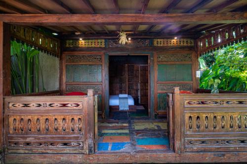 a room with two wooden fences and a bedroom at Kubu Kirana by Supala in Ubud