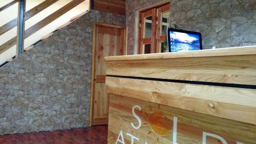 a room with a staircase with a tv on a stone wall at Hostal Sol de Atacama in Copiapó