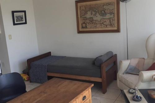 Habitación con cama, sofá y mesa. en Bonito departamento monoambiente con pileta y gym que cuenta con una cama de una plaza y un colchón extra para alojar un segundo huésped en Buenos Aires
