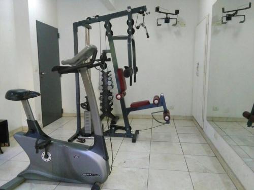 un gimnasio con cinta de correr en una habitación en Bonito departamento monoambiente con pileta y gym que cuenta con una cama de una plaza y un colchón extra para alojar un segundo huésped en Buenos Aires