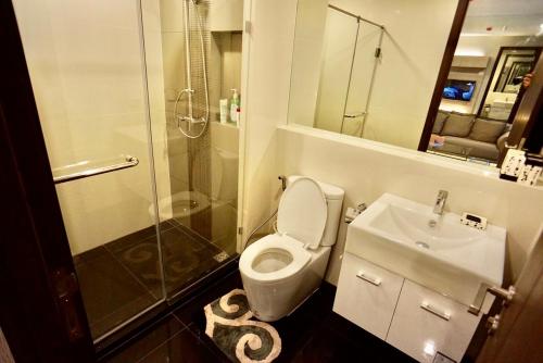 ein Bad mit einem WC, einem Waschbecken und einer Dusche in der Unterkunft Luxury Apartment near Downtown (Pick-up Service) in Bangkok