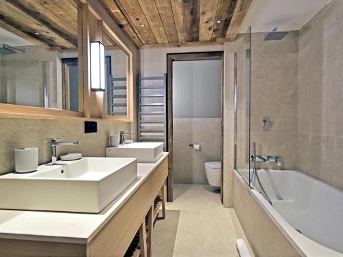 a bathroom with two sinks and a bath tub at Appartement Méribel, 4 pièces, 8 personnes - FR-1-613-51 in Les Allues