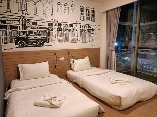 2 camas en una habitación con una foto en la pared en Kata Poshtel Phuket, en Kata Beach