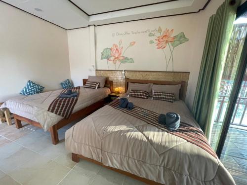 two beds sitting in a room with windows at เชียงคานพาราไดร์รีสอร์ท&มีตติ้ง in Ban Na Bon (1)