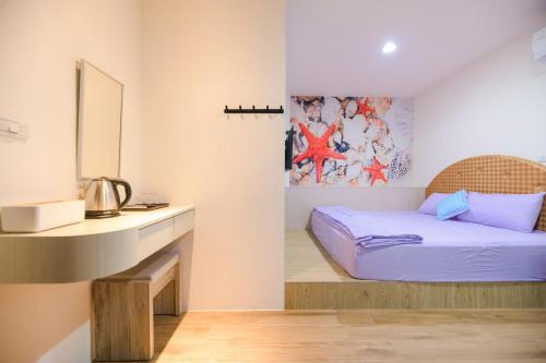 a small bedroom with a bed and a desk at 鴻滿億民宿 in Magong