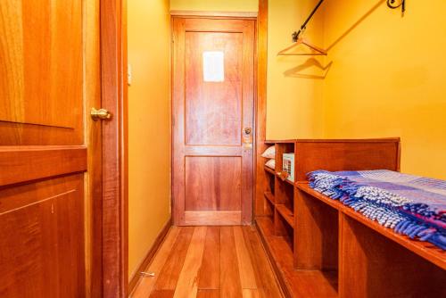 a room with a door and a bed and a hallway at Hotel Pakaritampu in Ollantaytambo