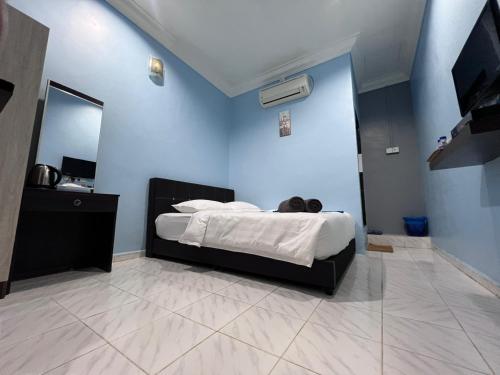 a bedroom with a bed in a blue wall at HOTEL RAUDHAH Kerteh in Kertih