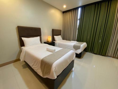 a hotel room with two beds and a window at Eight Breeze in Baclayon
