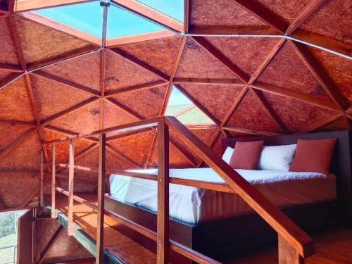 an attic room with a bed in a wooden ceiling at Glamping San Sebastian in Suesca